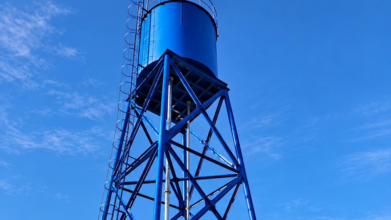 Estanque elevado de acero sobre torre metálica azul