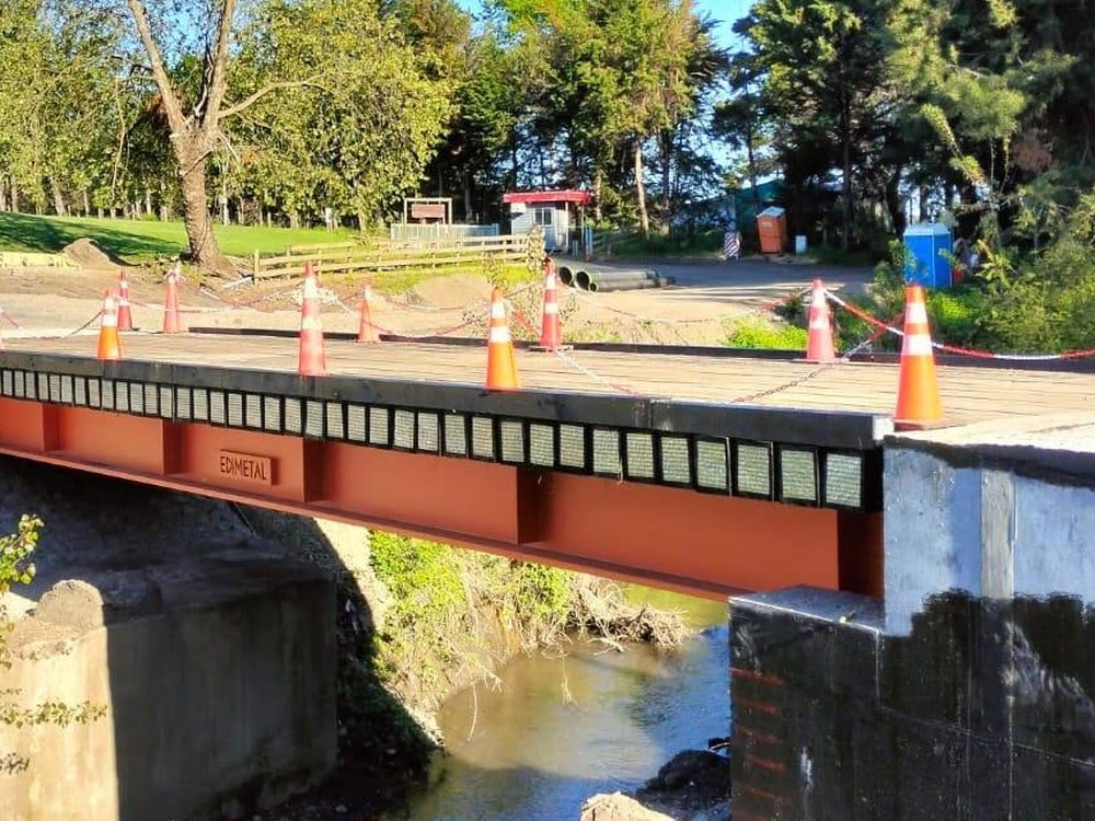 Puente de vigas de acero sobre un canal, con placa identificatoria EDIMETAL
